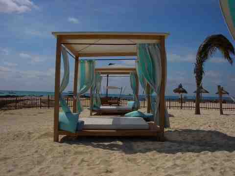 Beds on the beach with covers and side curtains.