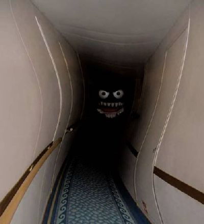 Monster head at the bottom of a dark and warped corridor.
