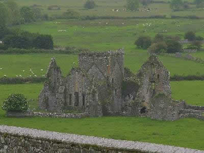 Pequeño castillo en ruinas en medio del campo verde.